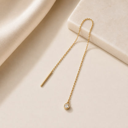 Goldene Kettenohrringe zum Durchziehen mit schwebendem Diamanten im minimalistischen Design